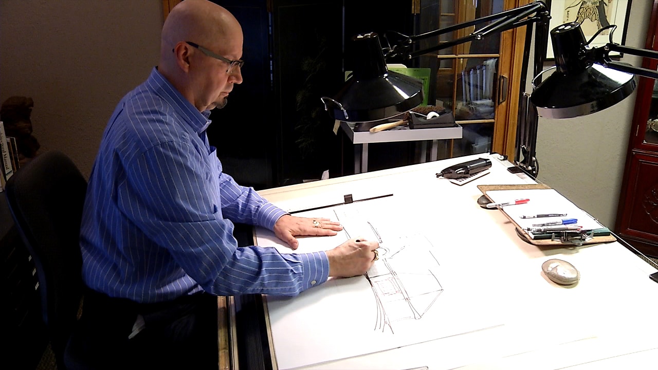 Kassee's dad drafting a blueprint by hand at his drawing table